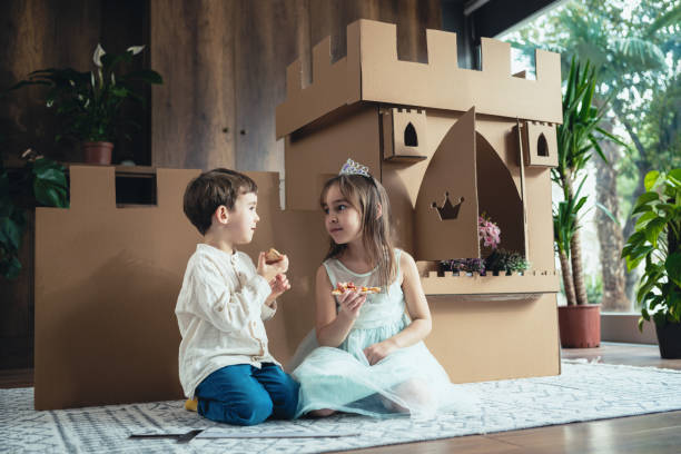 linda princesita y príncipe jugando juego de rol en casa con castillo hecho de cartón - princess castle child family fotografías e imágenes de stock