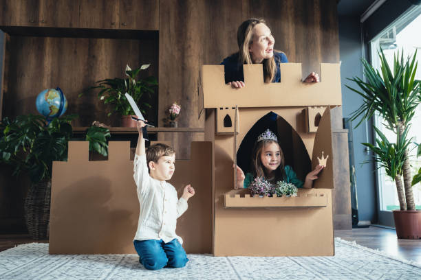 madre e hijos jugando juego de rol en casa con castillo hecho de cartón - princess castle child family fotografías e imágenes de stock