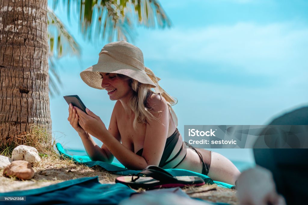 Woman Relaxing at Beach on Chair with Electronic Book Reader Beach Stock Photo
