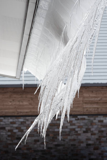 istock Row of icicles hanging from eaves on a roof 1475424362