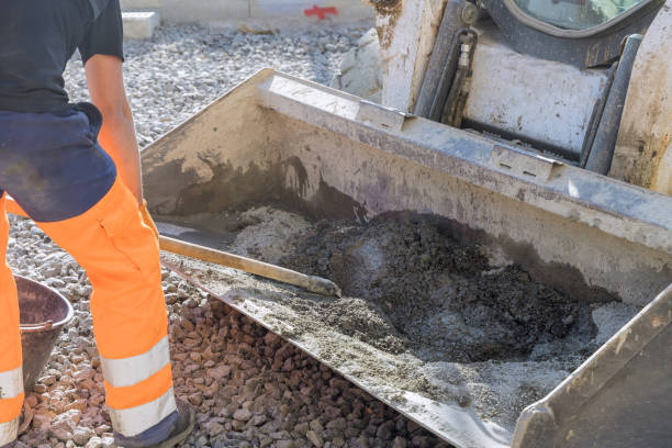 istock On a construction site, workers knead cement mortar into buckets of an excavator as they knead the materials. 1475428075