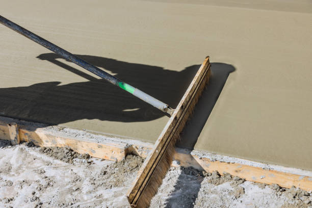 istock A construction laborer uses a broom to brush fresh wet concrete causing a groove texture pattern surface 1475428111