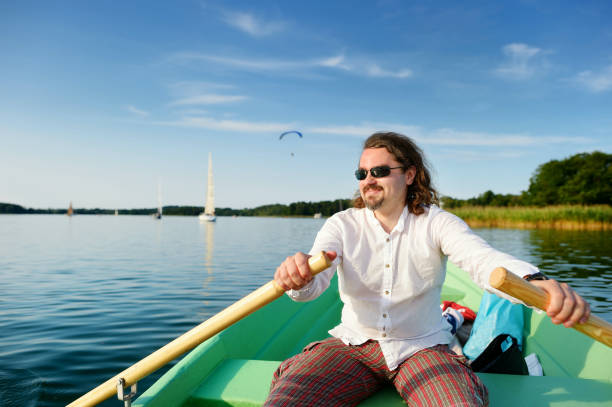 istock Young handsome man rowing a boat 1475429329
