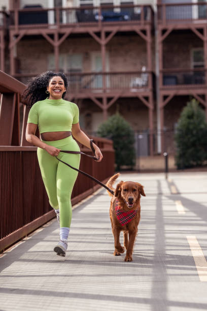 istock Cheerful young woman exercising outside with her dog 1475436144