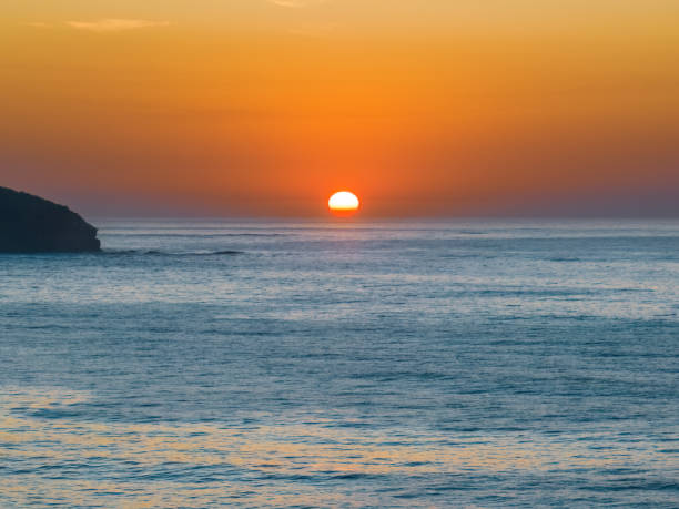 istock Soft hazy sunrise seascape with full sun and orange horizon 1475437311