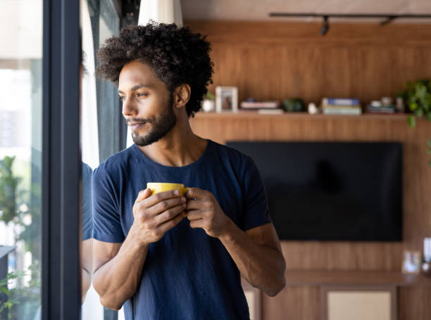 Thoughtful man drinking a cup of coffee at home