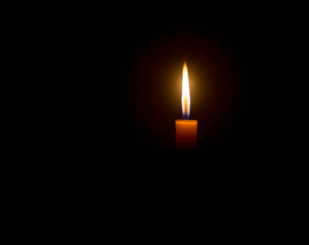 istock A single burning candle flame or light glowing on an orange cand 1475437776