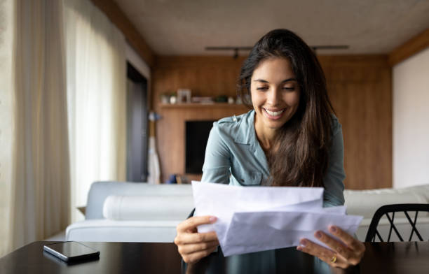 istock Happy woman reading a letter at home 1475437785