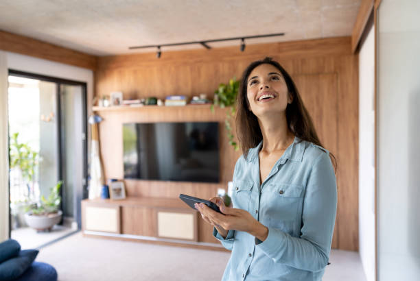 istock Woman controlling the lights in her house using an automated system 1475437843