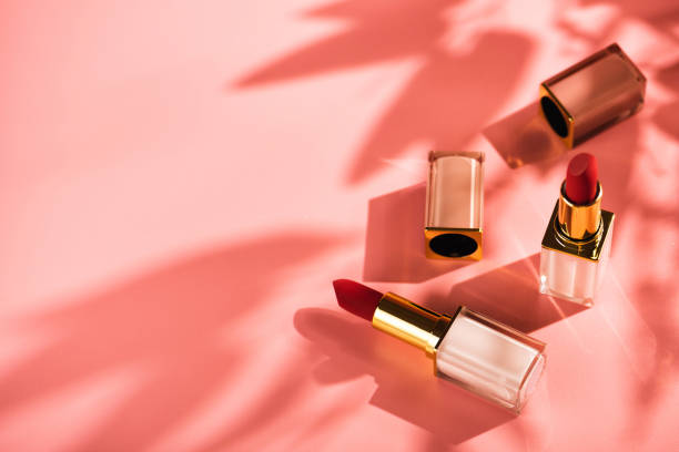 Red lipstick beauty product on a pink background Red lipstick beauty product on a pink background. Sun shadows from flowers, copy space makeup product photography stock pictures, royalty-free photos & images