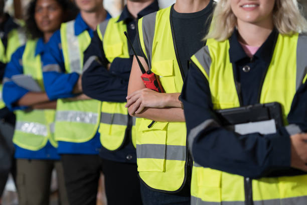 istock Group of warehouse workers standing with crossed arms in storage warehouse. Complete finish job. Successful of work concept 1475439594
