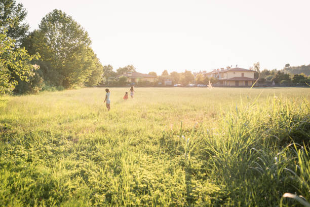 istock wide angle view on three children running in the field 1475441933
