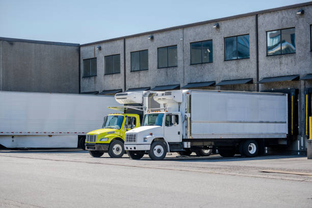 istock Affordable middle duty rigs semi trucks with refrigerated box trailers loading cargo standing in warehouse dock 1475443976