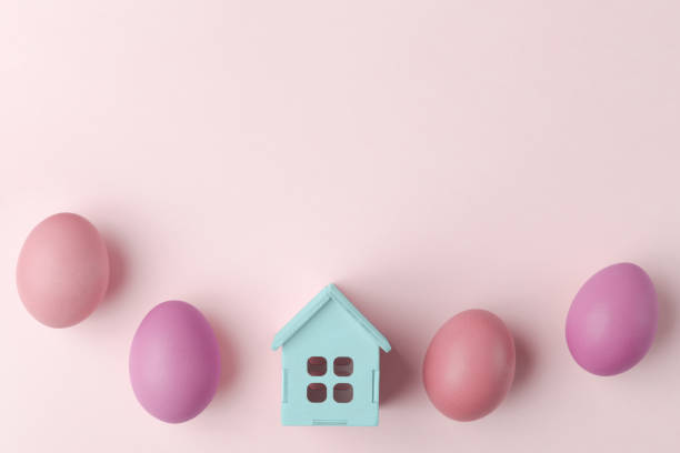 istock House model and painted Easter eggs on light pastel background with copy space 1475445494