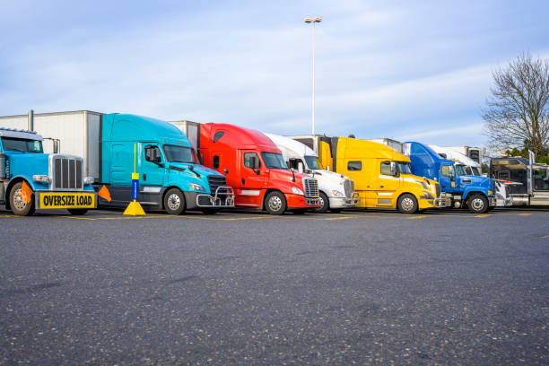 istock Different big rigs semi trucks with semi trailers standing in row on the reserved spots on truck stop parking lot 1475446329