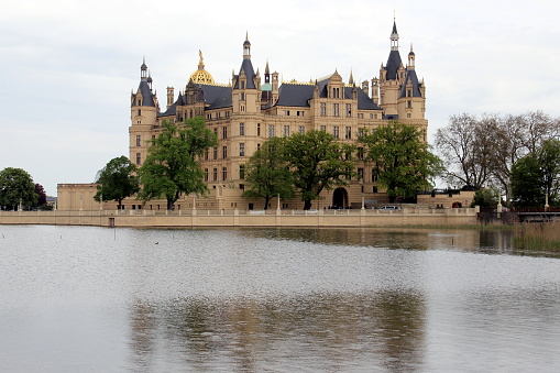 Schwerin Castle on the lake reflected in the water on a cloudy day, Schwerin, Germany