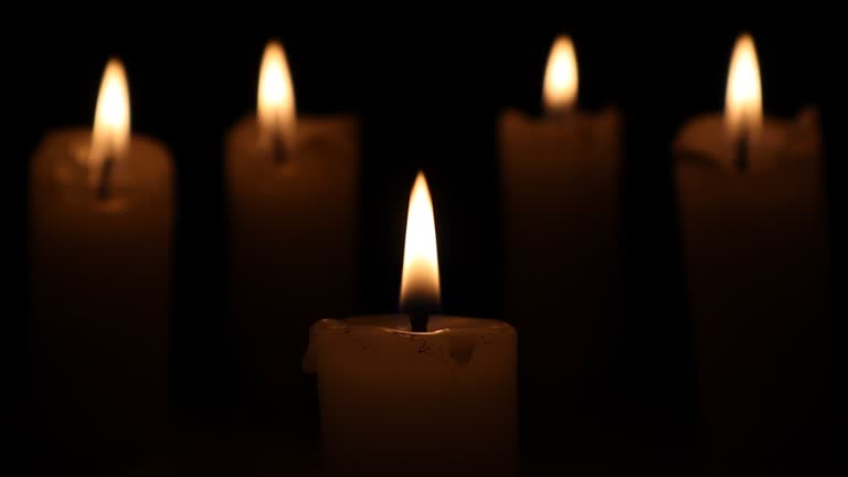 Several candles were burning in the darkness.