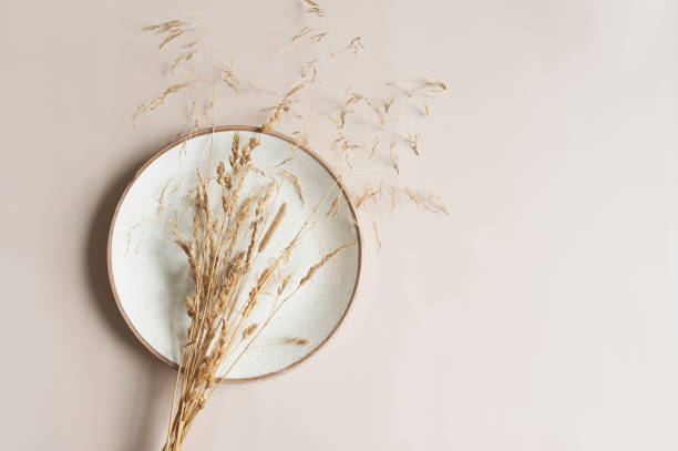istock beige empty plate on pastel background with dried flowers bouquet. Boho minimalist aesthetic. Dishware mock up 1475451888