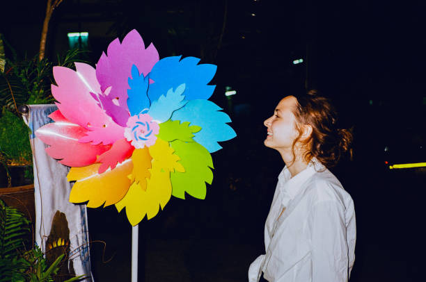 mujer de pie cerca de un gran molinete colorido - ferris wheel flash fotografías e imágenes de stock