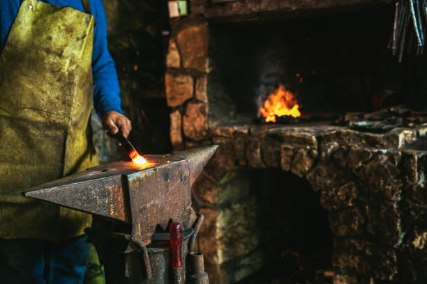 istock Blacksmith manually forging the molten metal on the anvil in smithy with spark fireworks, close up 1475455000