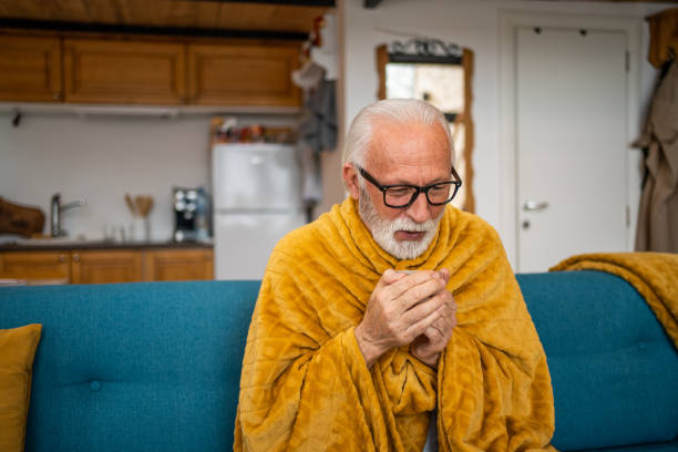istock An elderly man wrapped in a blanket is drinking tea, he has a cold 1475455598