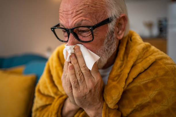 istock An elderly man sneezes, has a cold or flu, or is allergic to pollen. 1475456347