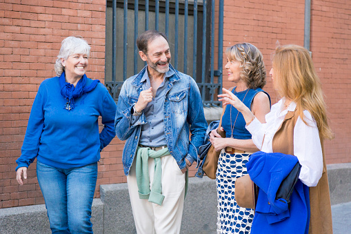 close up of group of happy middle-aged friends talking in the city