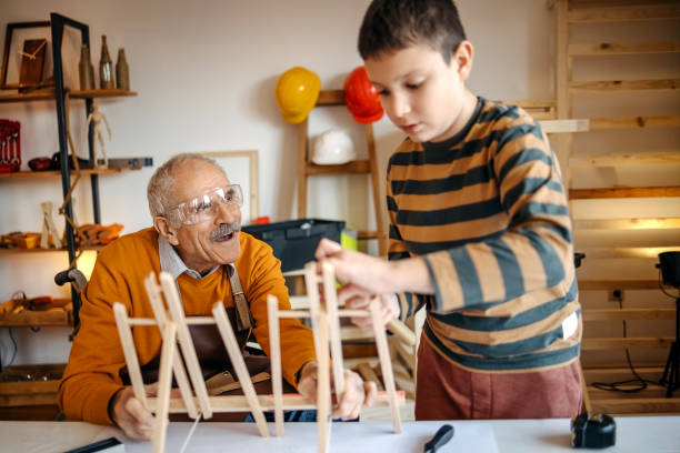 istock Boy helping grandfather   in his carpentry workshop 1475459457