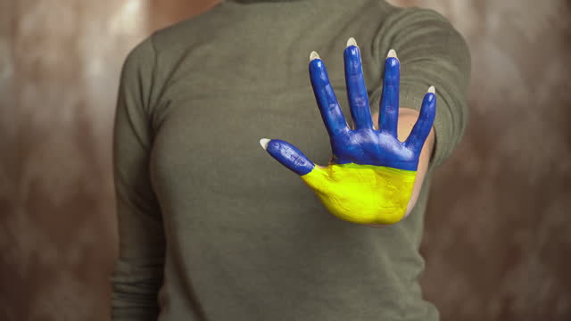 Hand of a Girl With the Flag of Ukraine Asks to Stop the War
