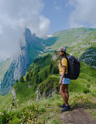 women hiking in the Swiss Alps mountains during summer vacation with a backpack and hiking boots. woman walking on the Saxer Lucke path