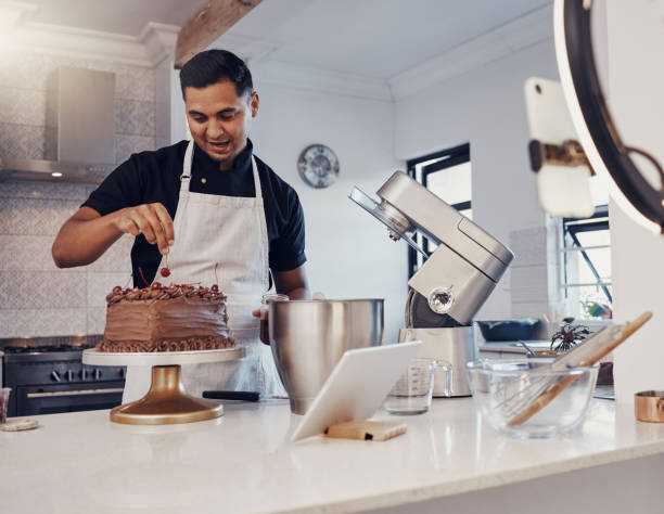 istock Man, vlog and baking chocolate cake in kitchen, live streaming and recording a dessert tutorial on social media. Happy chef, digital content creator or food influencer filming a virtual cooking class 1475462653