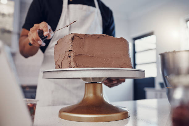 istock Frosting, baking and man with a cake in the kitchen for birthday food, dessert and pudding. Cooking, preparation and baker learning to decorate a sweet treat for a celebration on a table in a house 1475462665