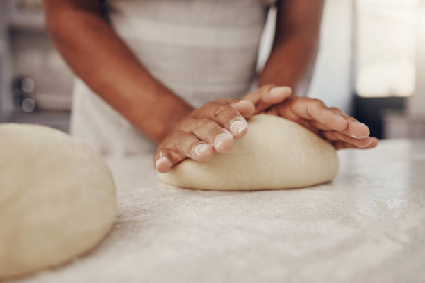 istock Man hands and dough press in kitchen for baking preparation work and process at culinary counter. Restaurant chef and worker in professional kitchen preparing wheat bread, cake or pizza recipe. 1475464059