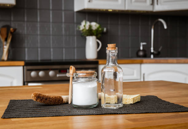 istock Using baking soda Sodium bicarbonate and white vinegar for home kitchen cleaning concept. White vinegar in glass bottle and baking soda in glass jar. 1475464189