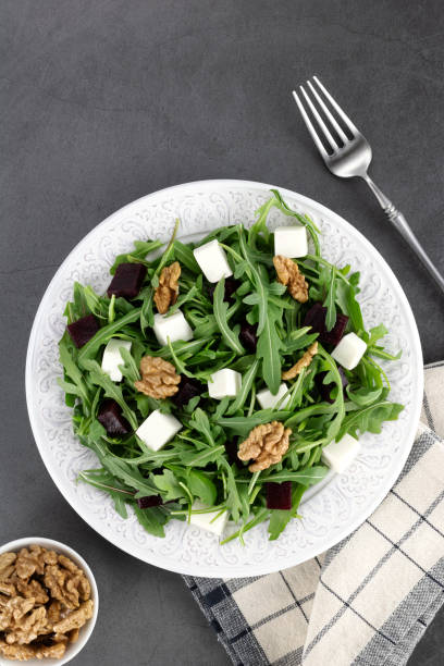 istock Beetroot salad with feta cheese, arugula and walnuts on a gray background. Top view. 1475464300
