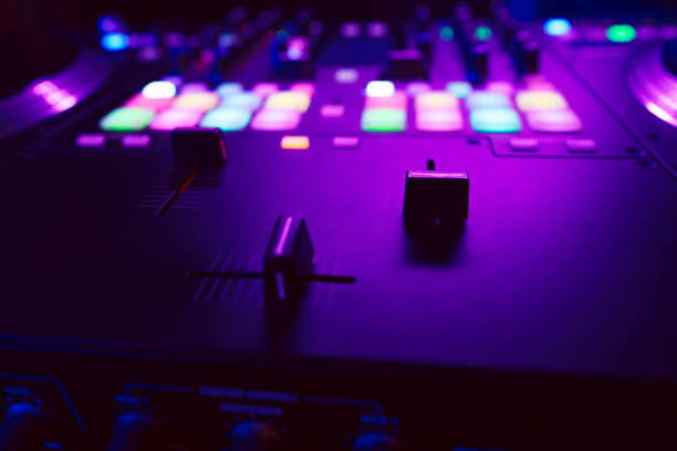 istock Close up of DJ mixing console in party light 1475468342