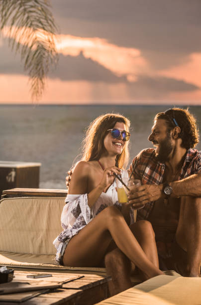 istock Happy couple talking while having drinks in a beach bar. 1475468568