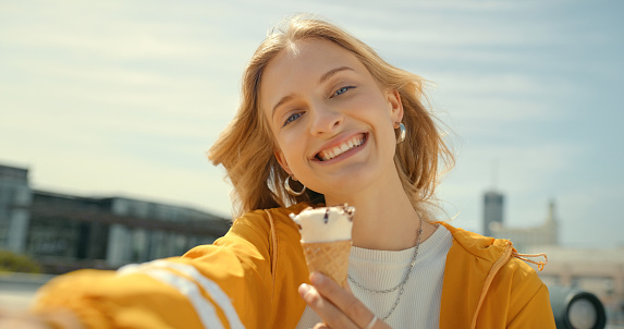Portrait, selfie and smile of woman with ice cream in city taking pictures for social media. Photographer, face and female eating gelato, sorbet or parfait on street and taking photo for happy memory