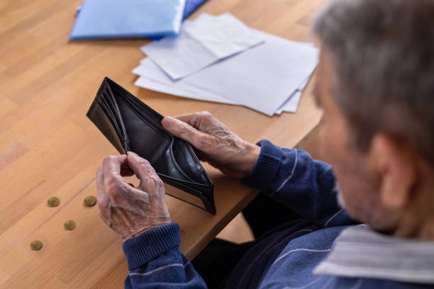 istock Close-up of an elderly man's hands holding an empty wallet. 1475472249