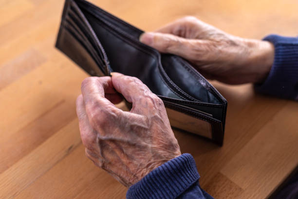 istock Close-up of an elderly man's hands holding an empty wallet. 1475472265