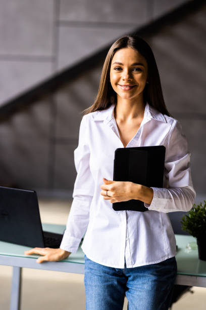 istock Smiling millennial woman stand using modern pad gadget at home browsing Internet or shopping, 1475472735