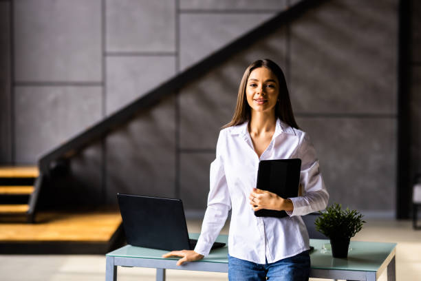 istock Smiling millennial woman stand using modern pad gadget at home browsing Internet or shopping, 1475474499