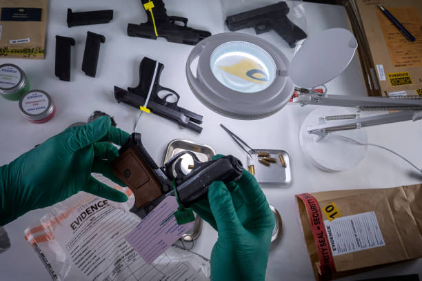 scientific police officer examining traces of a gun in ballistic laboratory - csi imagens e fotografias de stock