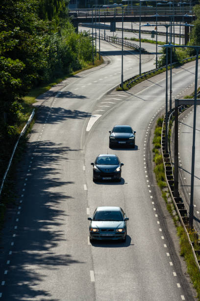 cars on a road merging from several lanes.. - two lane highway fotos imagens e fotografias de stock