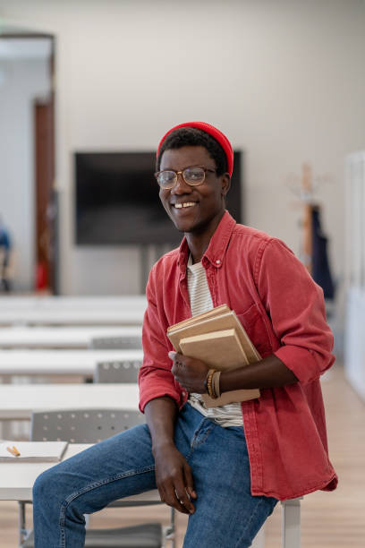 istock Happy smiling African guy university student in classroom or library 1475478332