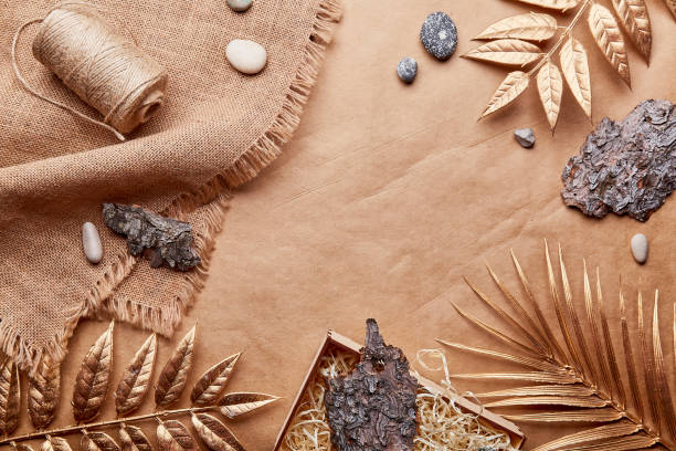 istock Natural brown eco-friendly, sustainable background with copy space. Natural Cotton Thread, tree bark, golden leaves, pebbles on crafting paper 1475479610