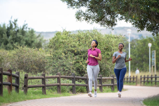 istock Front view friends running on footpath through natural parkland 1475480683