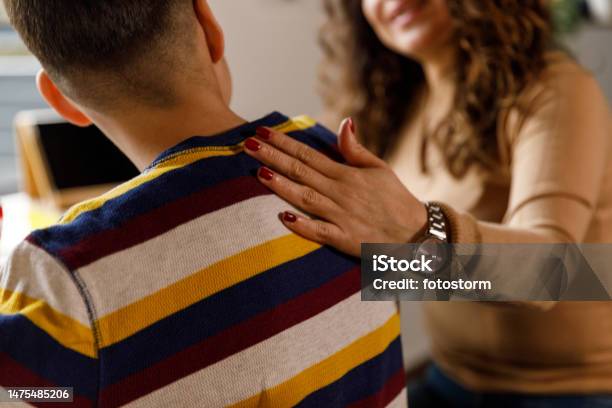 Mother Holding Hand On Her Sons Shoulder While Studying Stock Photo - Download Image Now