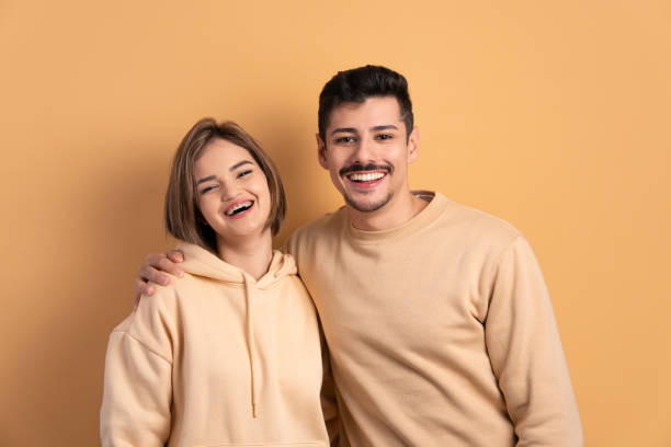 joyful couple smiling and looking at camera in studio shot. joy, people concept.