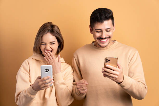 istock excited couple looking at mobile cell phone screen in beige background. network, messaging, internet concept. 1475488184
